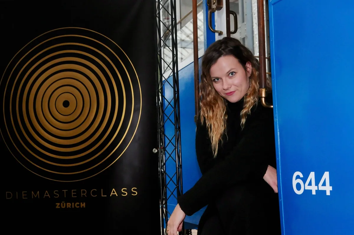 Man sieht eine Frau vor einem nostalgischen Tram.